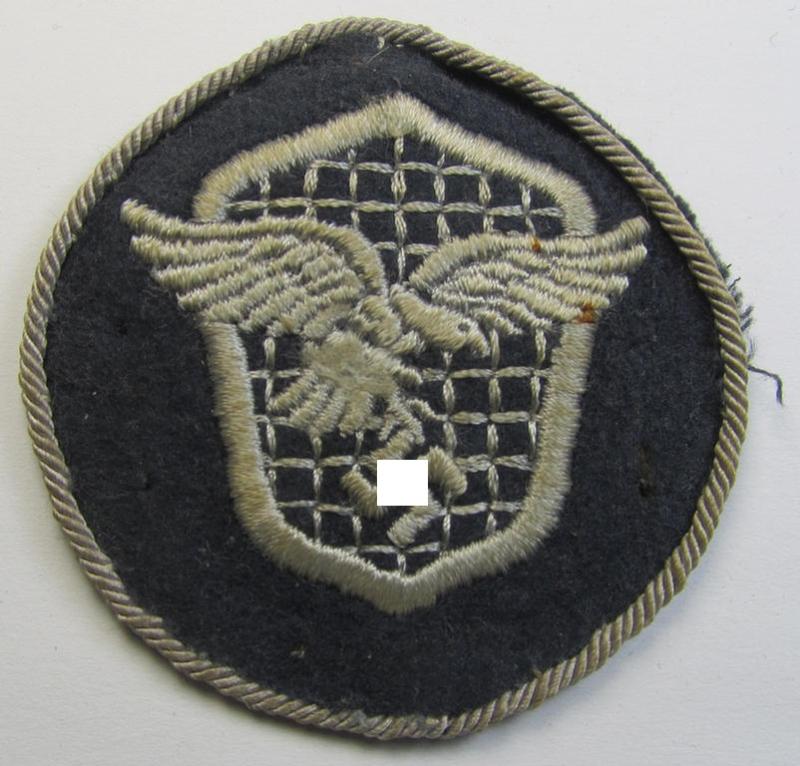 Attractive - and just moderately used - example of a WH (Luftwaffe) machine-embroidered, trade- ie. special-career-patch (ie. 'Tätigkeitsabzeichen') having a silverish-grey-toned 'Kordel' attached as was intended for: 'LW-Kraftfahrpersonal'