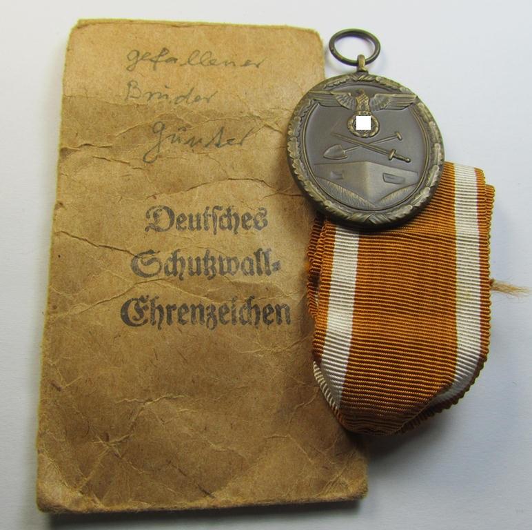 Attractive medal-set: 'Deutsches Schutzwall Ehrenzeichen' (aka: 'Westwall'-medal) being a typical non-maker-marked- and/or 'Buntmetall'-based specimen that comes packed in its original pouch of issue by the: 'Anton Marowsky's Sohn'-company
