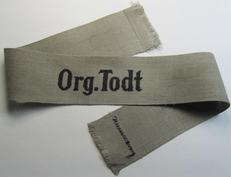 Attractive, OT (ie.: 'Organisation Todt') greyish-coloured, enlisted-mens'- (ie. NCO-) pattern cuff-title (ie. 'Ärmelstreifen für Mannschaften u. Unteroffiziere') being a moderately used- ie. tunic-removed example depicting the text: 'Org.Todt'