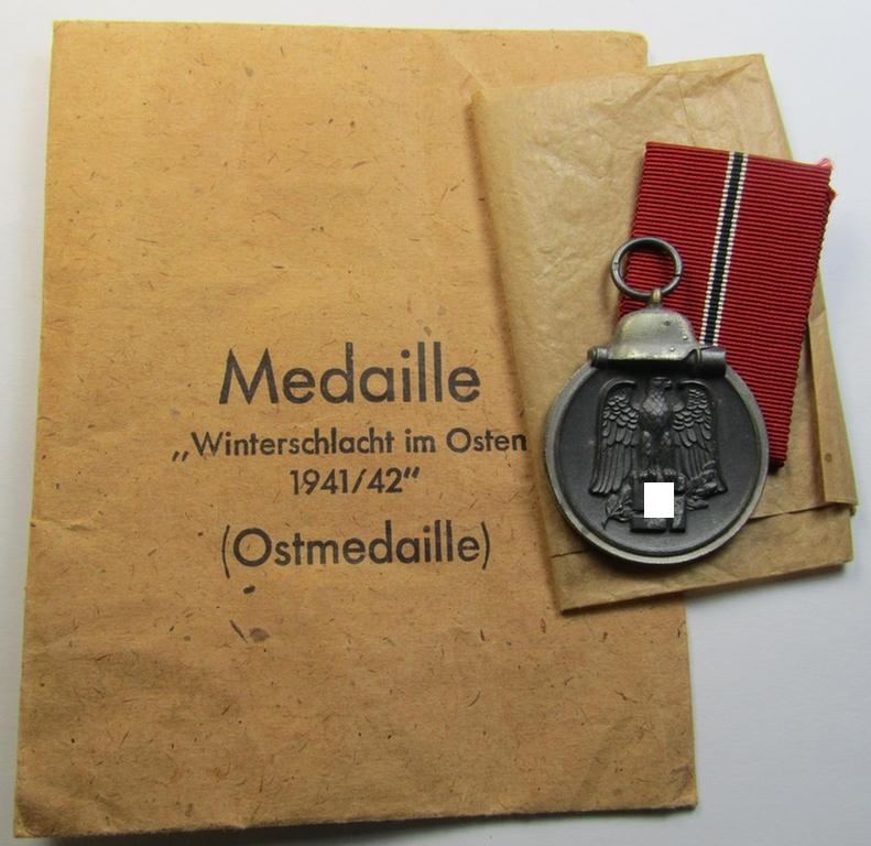 Superb medal-set: 'Winterschlacht im Osten 1941-42' being a maker- (ie. '11'-) marked specimen by the maker- (ie. 'Hersteller') named: 'Grossmann & Co.' and that comes packed in its original (larger-sized!) pouch of issue as recently found