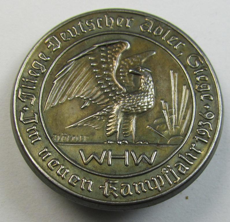 Bright silverish-toned- (and/or typical zinc-based) WHW-related day-badge (ie. 'tinnie' or: 'Veranstaltungsabzeichen') bearing the text: 'Fliege Deutscher Adler Siege - Im neuen Kampfjahr 1936'
