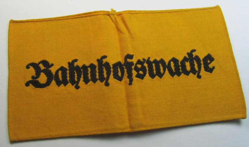 Very nice - and scarely encountered! - Wehrmacht-related, golden-yellow-coloured and/or typical linnen-based armband (ie. 'Armbinde') as executed in 'BeVo'-weave-pattern entitled: 'Bahnhofswache'