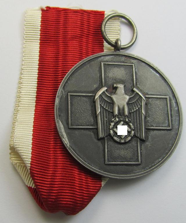 Attractive, silver-toned (and I deem 'Buntmetall'-based!) 'Deutsche Volkspflege'- (ie. civil-service) medal being a non-maker-marked example that came together with its (confectioned- and somewhat shortened) ribbon (ie. 'Bandabschnitt')