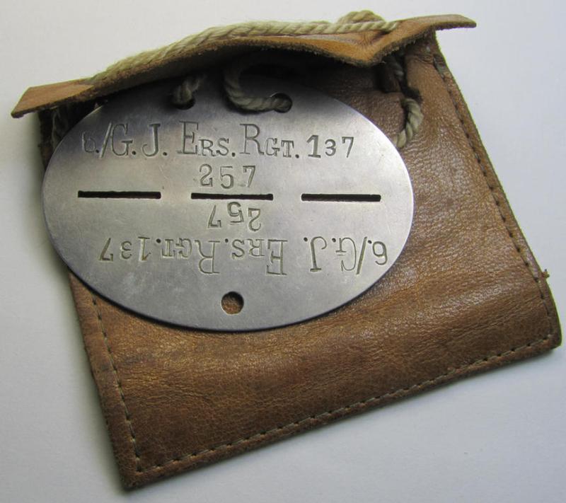 Superb - and scarcely found! - typical aluminium-based, WH (Heeres-) ie. 'Gebirgsjäger'-related ID-disc (ie. 'Erkennungsmarke') bearing the stamped unit-designation: '6./G.J.Ers.Rgt.137' and that comes stored in its period pouch as issued