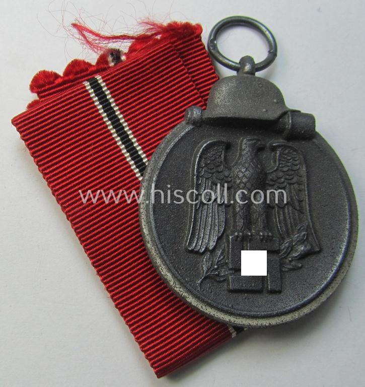 Attractive medal-set: 'Winterschlacht im Osten 1941-42' being a maker- (ie. '13'-) marked- (and/or 'Feinzink'-based) specimen by the maker: 'Gustav Brehmer' and that comes together with its (non-confectioned) ribbon (ie. 'Bandabschnitt')