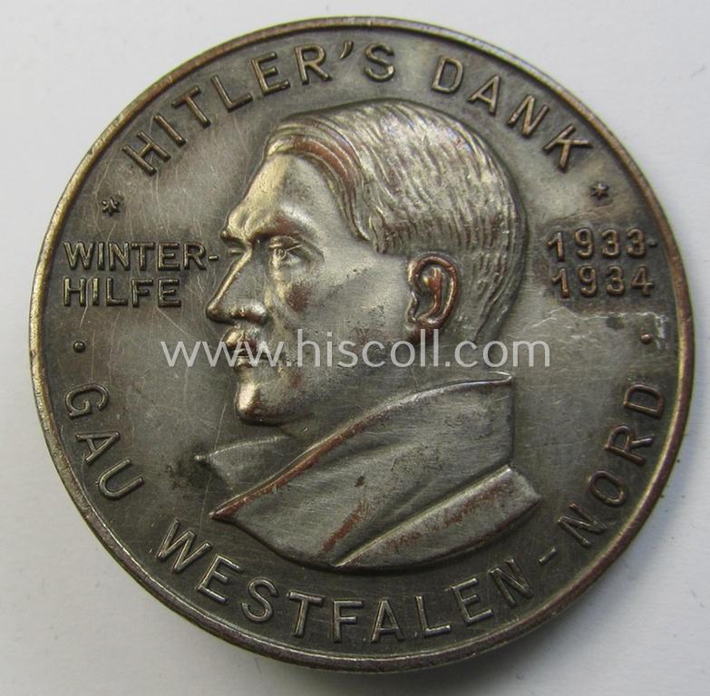 Commemorative - 'Buntmetall'-based- and/or silver-coloured - N.S.D.A.P.- (ie. WHW-) related 'tinnie', being a maker- (ie. 'Paulmann u. Crone'-) marked example depicting Adolf Hitler surrounded by the text: 'Hitlers' Dank - Gau Westfalen-Nord'