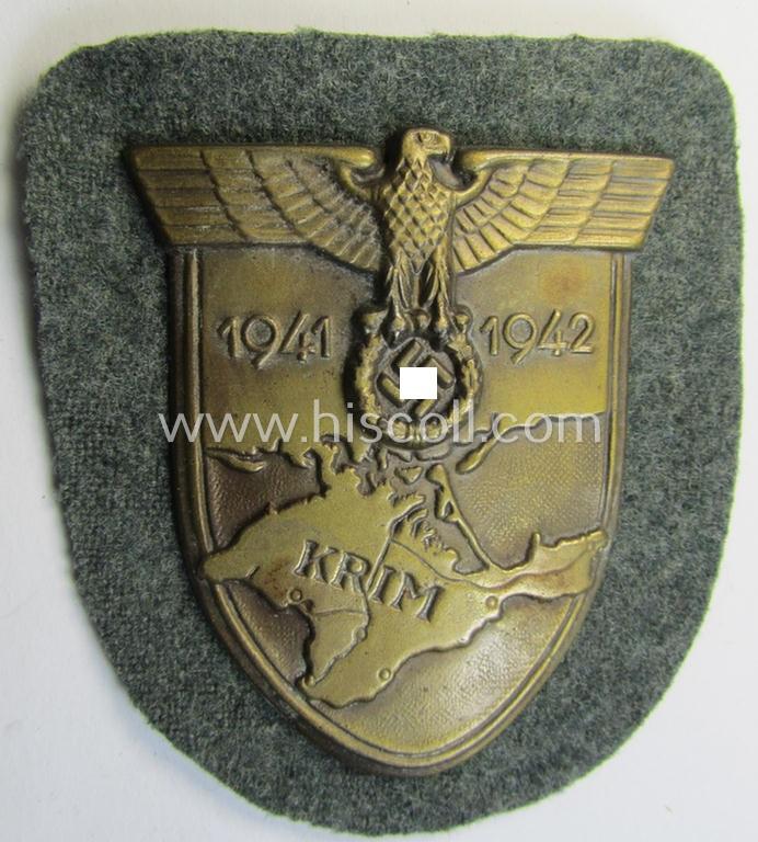 Attractive, WH (Heeres o. Waffen-SS) 'Krim'-campaign-shield that comes mounted onto its original, field-grey-coloured 'backing' and that comes in an issued-, minimally worn and/or (I deem) carefully tunic-removed-, condition