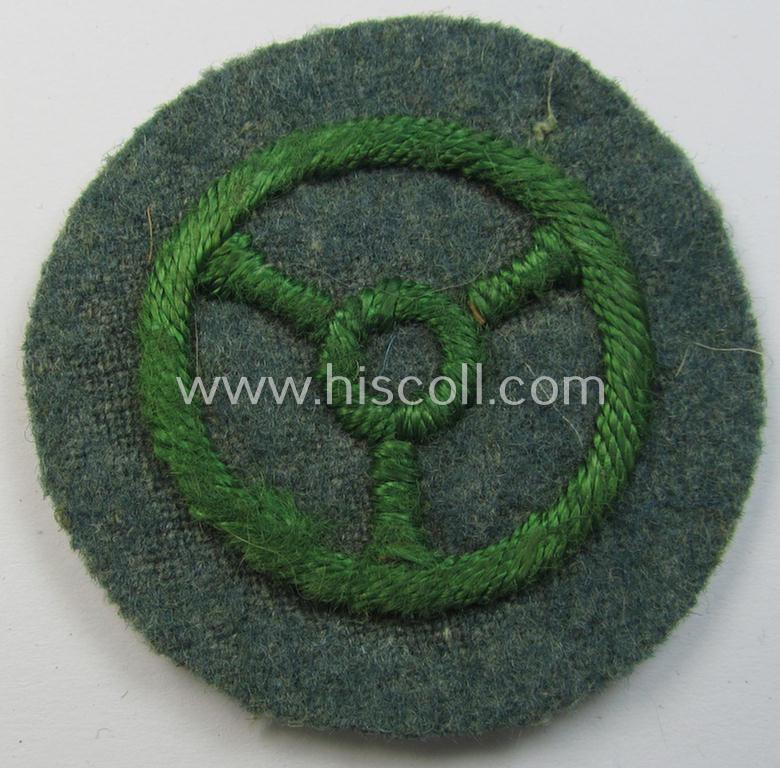 Police- (ie. 'Schutzpolizei'-) related, neatly hand-embroidered, trade- ie. special-career patch (ie. 'Laufbahn- o. Tätigkeitsabzeichen') depicting a bright-green-coloured steering-wheel as was intended for: 'Kraftfahrpersonal'
