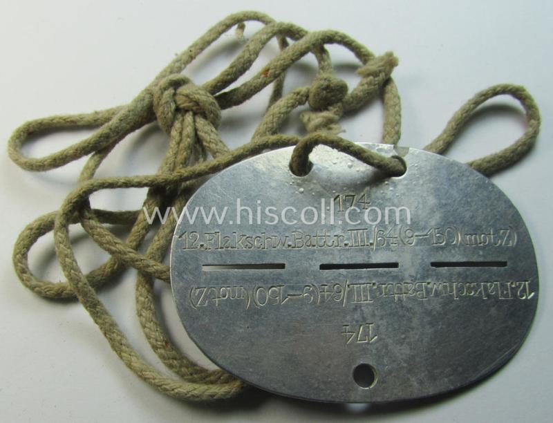 Attractive - and aluminium-based - WH (Luftwaffe) ie. 'Flak'-related ID-disc (ie. 'Erkennungsmarke') bearing the unit-designation that simply reads: '12.Flakschw.Battr.III./64 (9-150)(motZ)' and that comes mounted on its period cord