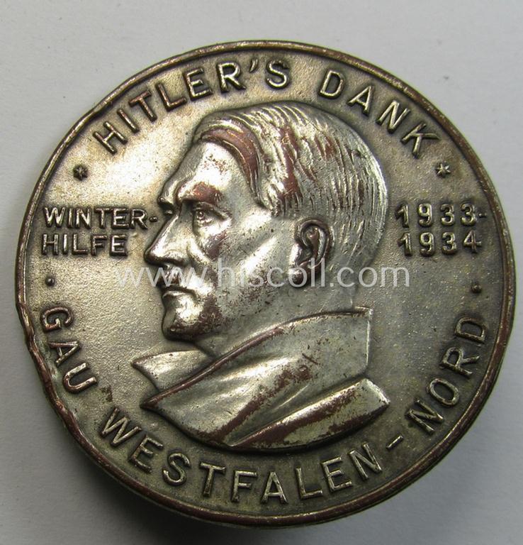 Commemorative, silvered 'Buntmetall'-based N.S.D.A.P.- (ie. WHW-) related 'tinnie' being a maker- (ie. 'Paulmann u. Crone'-) marked example depicting A.Hitler and text: 'Hitler's Dank - Winterhilfe 1933-1934 - Gau Westfalen-Nord'