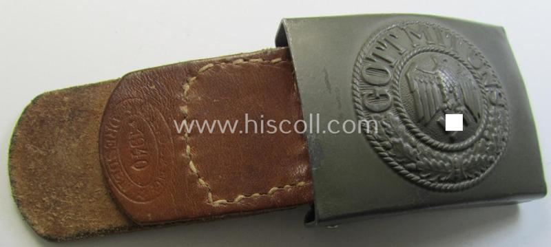 Attractive, WH (Heeres) field-grey-coloured- and/or steel-based belt-buckle being a maker- (ie. 'G.H. Osang'-) marked- and/or '1940' dated example that comes mounted onto its leather-based tab and that comes in a wonderful condition