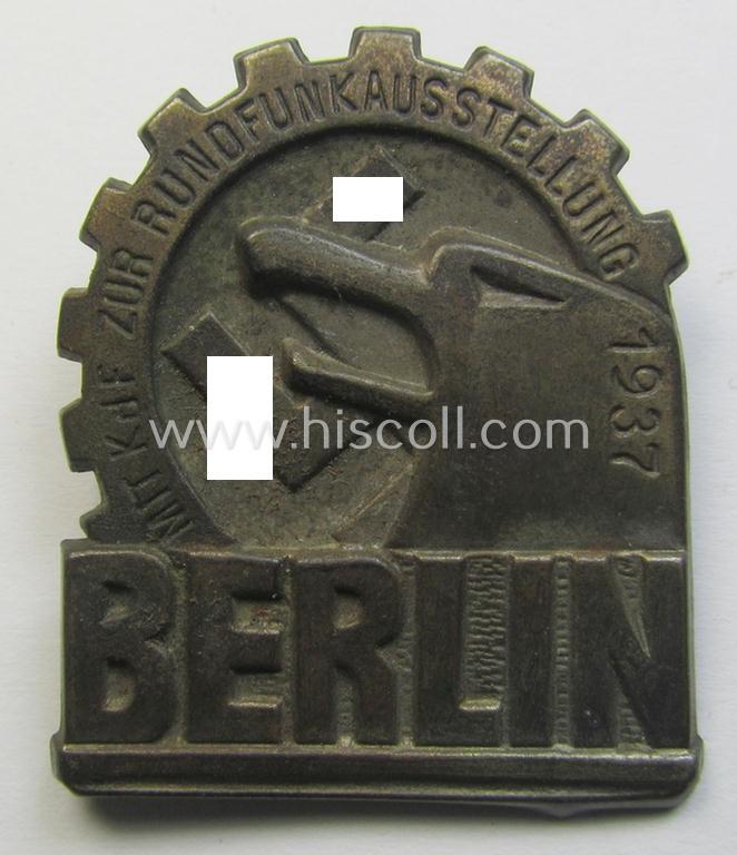Attractive, so-called: 'KdF'- ('DAF- o. Kraft durch Freude'-) related day-badge (ie. 'tinnie') depicting a eagles'-head, 'DAF-Zahnrad' and text that reads: 'Mit KDF zur Rundfunkaustellung - Berlin - 1937'