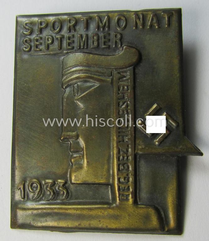 Bright-golden-toned, tin-based so-called: 'NS-sports'-related 'tinnie' being a non-maker-marked example depicting a stylised 'art-deco'-type figure and swastika coupled with the text: 'Sportmonat September 1935 - Reg. Bez. Hildesheim'