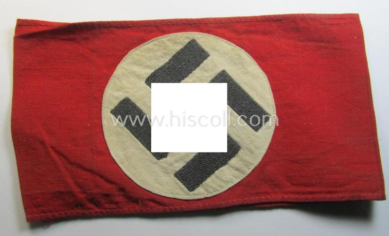 Superb - and just moderately used! - so-called: N.S.D.A.P.-related party-armband (ie. 'Armbinde') being of the 'partly woven'-pattern showing an interwoven ie. 'machine-embroidered' swastika (ie. roundel)