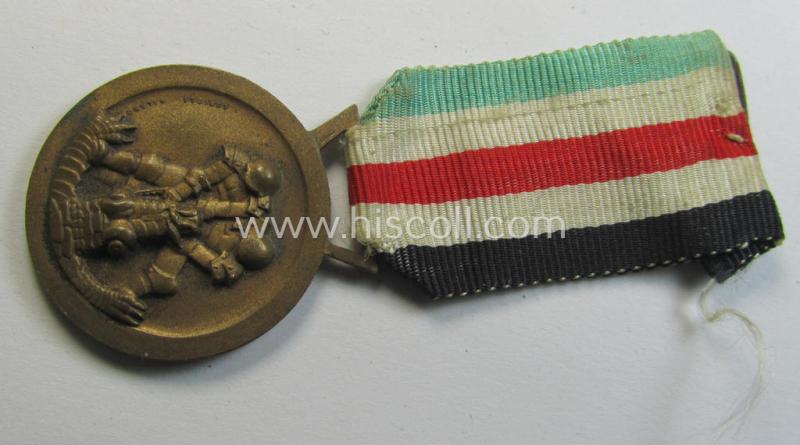 Attractive, golden-bronze-coloured- (and I deem 'Buntmetall'-based-) example of a: 'Deutsch-Italienische Feldzugsmedaille' (or: German-Italian campaign-medal) that comes mounted onto its (regular-sized) piece of original ribbon