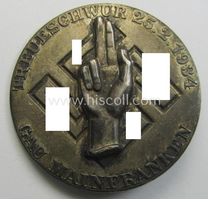 Commemorative - 'Buntmetall'-based-, N.S.D.A.P.-related 'tinnie', being a maker- (ie. 'Wächtler u. Lange'-) marked example depicting an oath-taking hand above a swastika surrounded by the text: 'Treueschwur 25-2-1934 - Gau Mainfranken'
