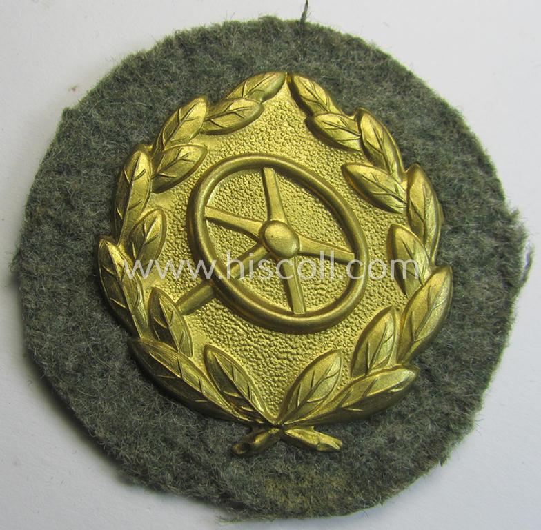 Superb, WH (Heeres- ie. Waffen-SS): 'Kraftfahrbewährungs-Abzeichen in Gold' (or: golden-class drivers' proficiency-badge) that comes mounted onto its piece of field-grey-coloured wool and that comes as probably issued- but never worn, condition