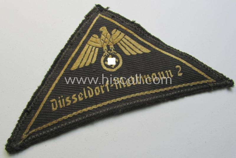 Attractive, German Red Cross (ie. 'Deutsches Rotes Kreuz' or 'DRK') related, EM- (ie. NCO-) type, greyish-coloured- and/or (typically) triangular-shaped arm-eagle as executed in the neat 'BeVo'-weave pattern entitled: 'Düsseldorf-Mettmann 2'