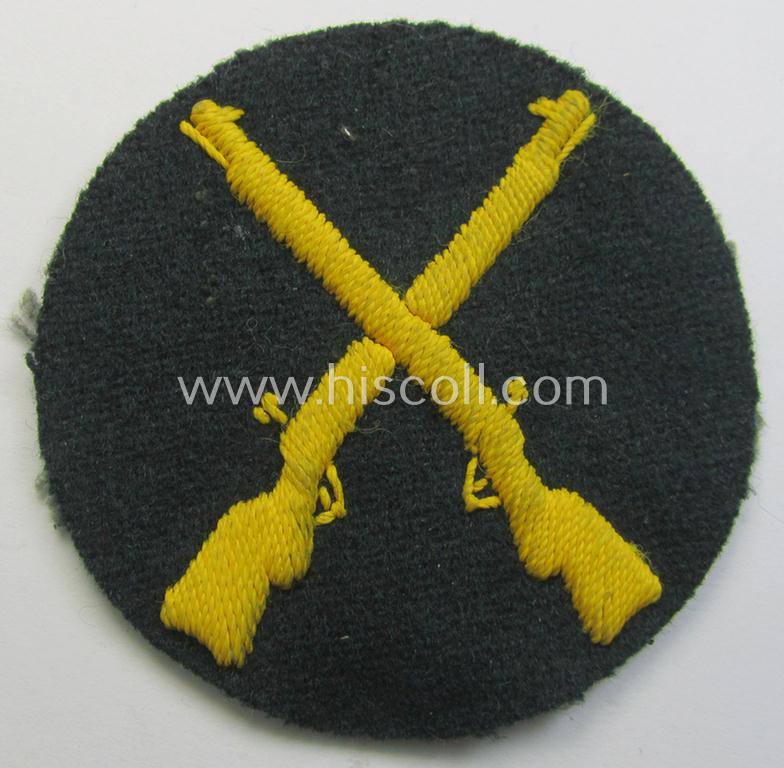 Neat, WH (Heeres) hand-embroidered, trade- ie. special-career arm-patch as was intended for a: 'Waffenmeister' (or: weapon-equipment NCO) being a maker-marked example as executed on darker-green-coloured wool
