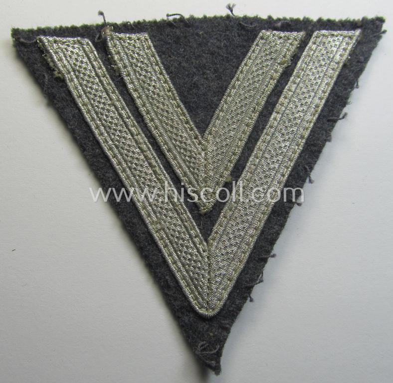 Neat - clearly used and/or tunic-removed - WH (Luftwaffe) 'Armwinkel' (or: arm-chevron) as executed on typical bluish-grey-coloured wool as was specifically intended for usage by a soldier with the rank of: 'Obergefreiter'