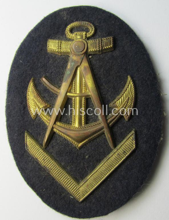 Attractive - and actually scarcely encountered! - WH (Kriegsmarine) golden-toned, so-called: career- ie. specialist-armbadge (ie. 'Dienstgrad-Abzeichen') as was specifically intended for usage by an: 'Oberzimmermannsmaat' (ie. senior naval-carpenter)