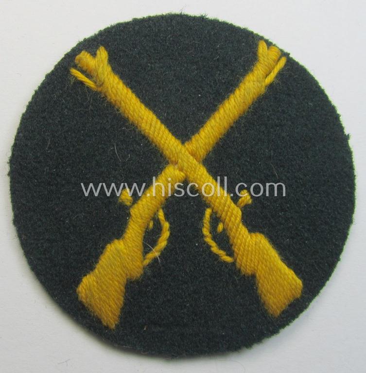 Neat, WH (Heeres) hand-embroidered, trade- ie. special-career arm-patch as was intended for a: 'Waffenmeister' (or: weapon-equipment NCO) being a maker-marked example as executed on darker-green-coloured wool