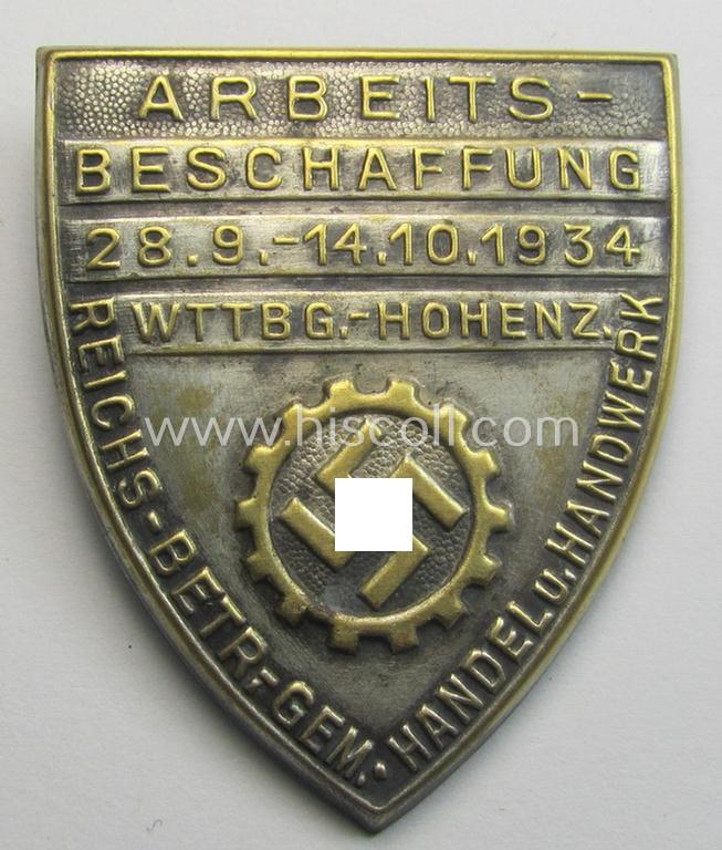 Silver-toned- (and/or tin-based) RAD- (ie. 'Reichsarbeitsdienst'-) related day-badge depicting a so-called: 'RAD-Zahnrad' and text: 'Arbeitsbeschaffung - 28.9.-14.10.1934 - Wttbg. Hohenz.' and sub-titled: 'Reichs-Betr. Gem. - Handel u. Handwerk'