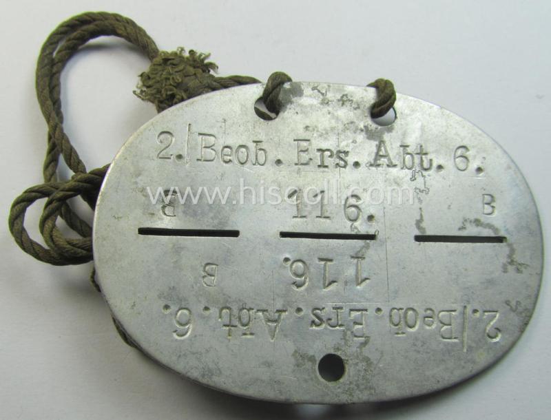 Attractive - and not that easily found! - aluminium-based, WH (Heeres-) ie. 'Artillerie-Beobachtungs'-related ID-disc bearing the clearly stamped unit-designation that reads: '2./Beob.Ers.Abt. 6' and that comes mounted onto its period-cord as issued