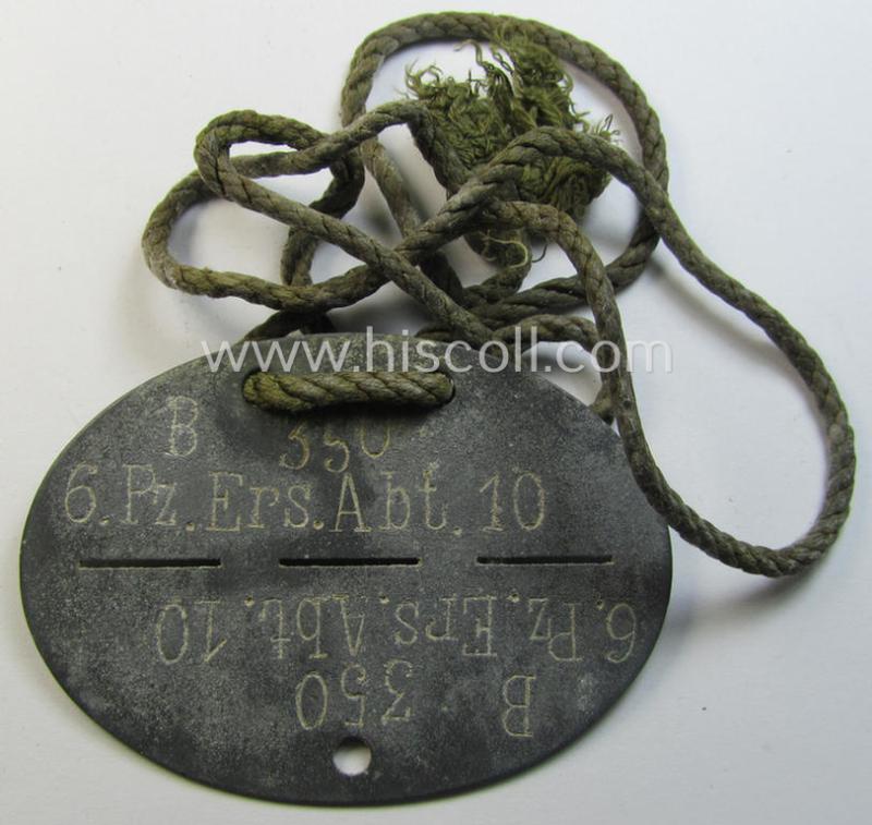 Superb - and scarcely found! - typical zinc-based, WH (Heeres-) ie. 'Panzer'-related ID-disc (ie. 'Erkennungsmarke') bearing the clearly stamped unit-designation that reads: '6.Pz.Ers.Abt.10' and that comes mounted onto its period-cord as issued