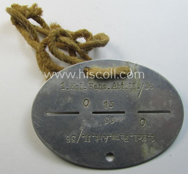 Superb - and scarcely found! - typical aluminium-based, WH (Heeres-) ie. 'Panzer'-related ID-disc (ie. 'Erkennungsmarke') bearing the clearly stamped unit-designation that reads: '1.Kol.Panz.Abt.II/36' and that comes mounted onto its period-cord