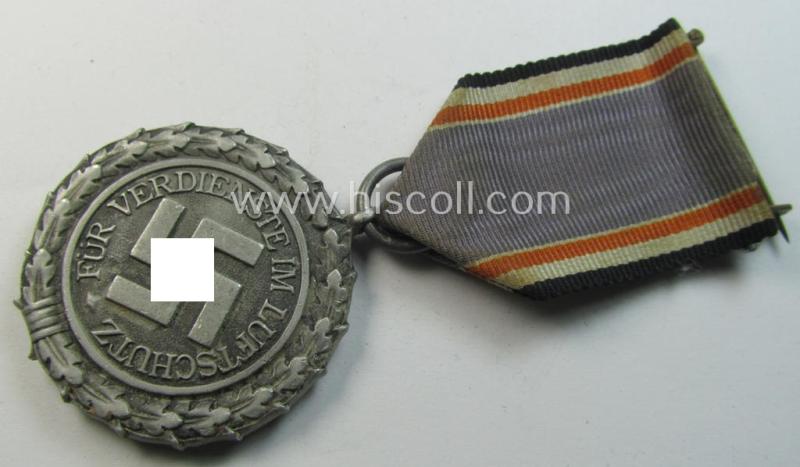 Neat, 'Luftschutz-Ehrenzeichen 2. Stufe' being a non-maker-marked example as executed in (light-weight) aluminium-based metal and that comes mounted onto its period (confectioned) ribbon ie. 'Bandabschnitt'