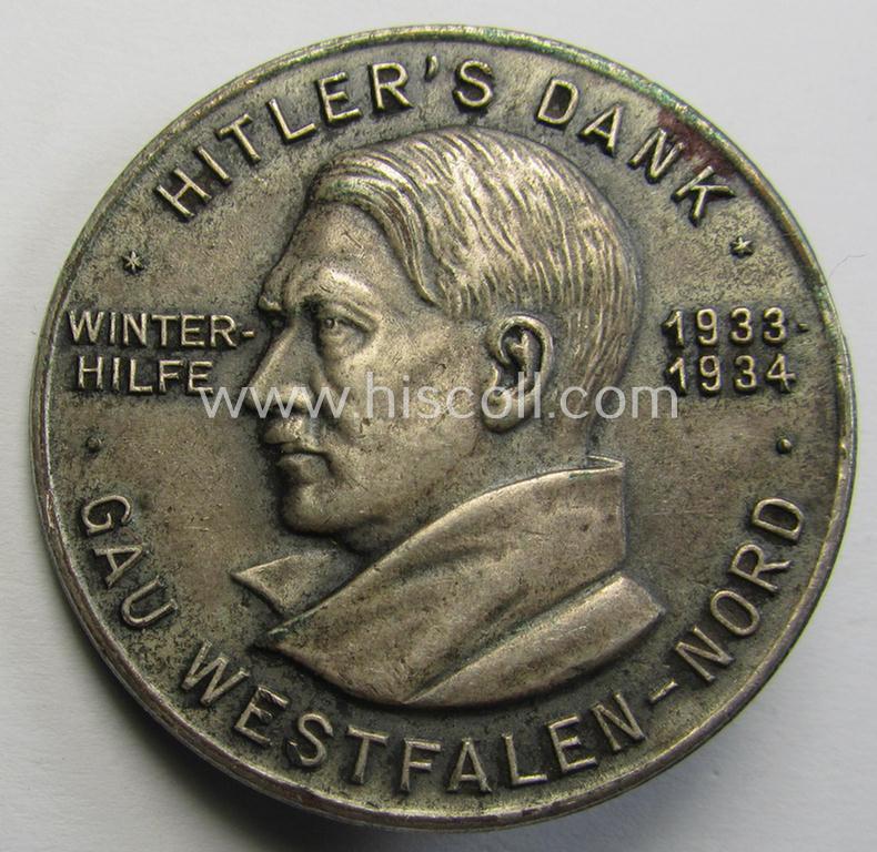 Commemorative, silvered 'Buntmetall'-based N.S.D.A.P.- (ie. WHW-) related 'tinnie' being a maker- (ie. 'Paulmann u. Crone'-) marked example depicting Adolf Hitler and showing the text: 'Hitler's Dank - Winterhilfe 1933-1934 - Gau Westfalen-Nord'
