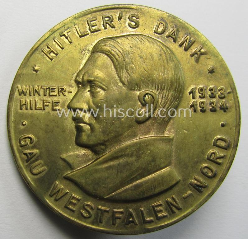 Commemorative, golden 'Buntmetall'-based N.S.D.A.P.- (ie. WHW-) related 'tinnie' being a maker- (ie. 'Paulmann u. Crone'-) marked example depicting Adolf Hitler and showing the text: 'Hitler's Dank - Winterhilfe 1933-1934 - Gau Westfalen-Nord'