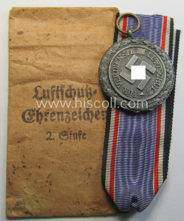 Attractive, 'Luftschutz-Ehrenzeichen 2. Stufe' being a non-maker-marked example, as executed in zinc-based metal (ie. 'Feinzink') and that comes stored in its (scarcely seen!) 'Zellstoff'-based pouch by the maker: 'Katz u. Deyhle'