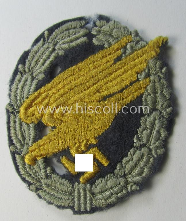 WH (Luftwaffe) 'Fallschirmschützen-Abzeichen in Stoff' (or: cloth-based paratroopers'-jump-badge) being a nicely machine-embroidered specimen that comes in a clearly issued, moderately worn and/or carefully tunic-removed-, condition
