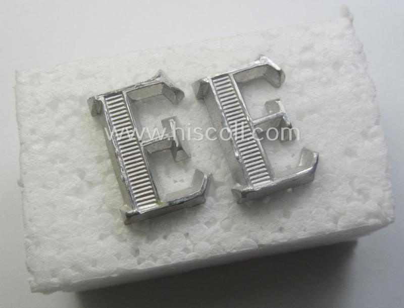 Pair of NCO-type- (thus silver-coloured), Waffen-SS- (ie. SS-VT-) related shoulderstrap-cyphers (ie. 'Schulterstückauflagen o. Ziffern') depicting a capital 'E'-character for usage by an NCO serving within the: 'Ergänzungsstellen der Waffen-SS'