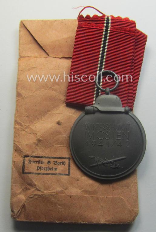 Fully matching medal-set: 'Winterschlacht im Osten 1941/42' as produced by the: 'Foerster & Barth'-company being a clearly maker- (ie. '10'-marked) specimen that came stored in its original 'Zellstoff'-based pouch of issue as found