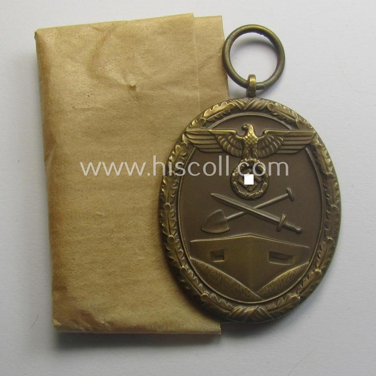 Stunning, 'Deutsches Schutzwall Ehrenzeichen' (aka: 'Westwall'-medal) being a (typical) non-maker-marked- and/or: 'Buntmetall'-based specimen that comes packed in its original pouch of issue by the: 'Friedrich Orth'-company